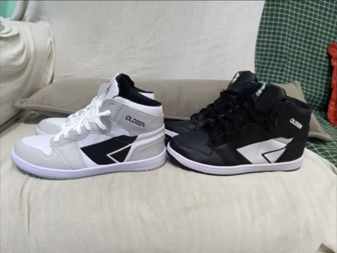 Side view of two Jordan 1s bootlegs, one black, one grey.